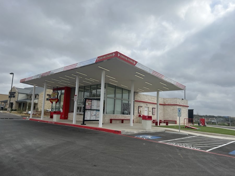 Andy&rsquo;s Frozen Custard exterior with a red and white drive-thru canopy, menu boards and stone-clad servery