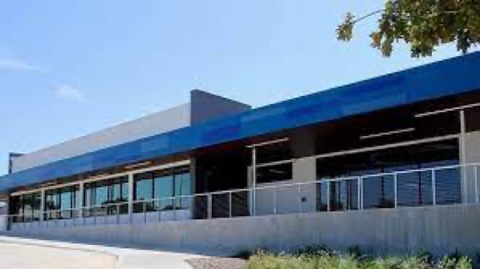 Arlington Early College exterior with a blue metal fascia, glazed classrooms and a cable balustrade