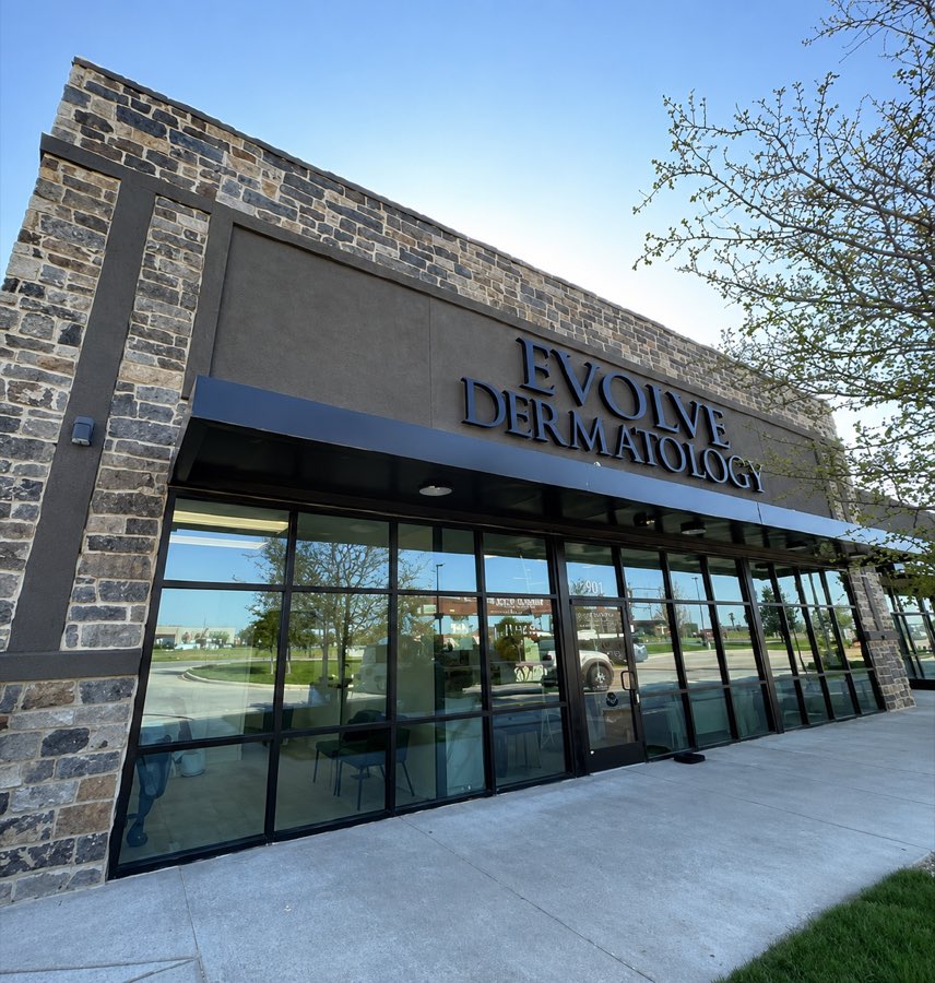 Evolve Dermatology clinic exterior in stone and glass with a full-height curtain wall