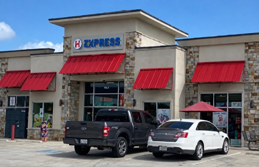 H Express convenience store exterior in stone and stucco with red awnings