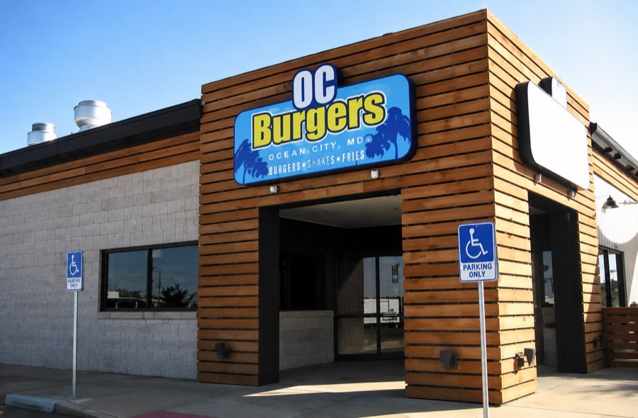 OC Burger exterior with horizontal timber cladding and a recessed entry canopy