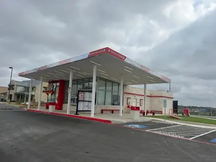 Andy&rsquo;s Frozen Custard exterior with a red and white drive-thru canopy, menu boards and stone-clad servery
