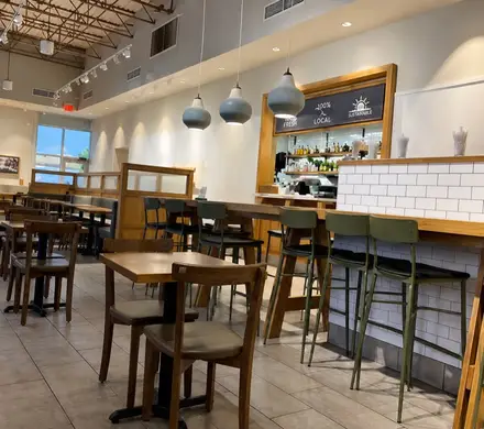 Panera Bread dining room with pendant lighting, timber banquettes and a tiled service counter